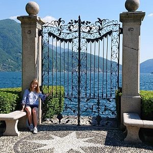 ein Mädchen posiert vor einem Tor an einem See