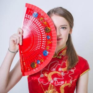 Schülerin in traditioneller chinesischer Kleidung mit einem Fächer